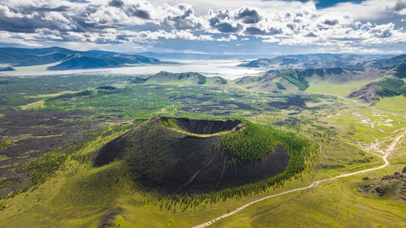 A volcanic crater surrounded by green plains and lakes