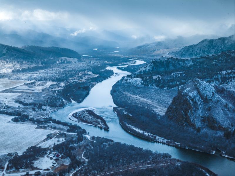 A river bending through wooded hills, seen from the air