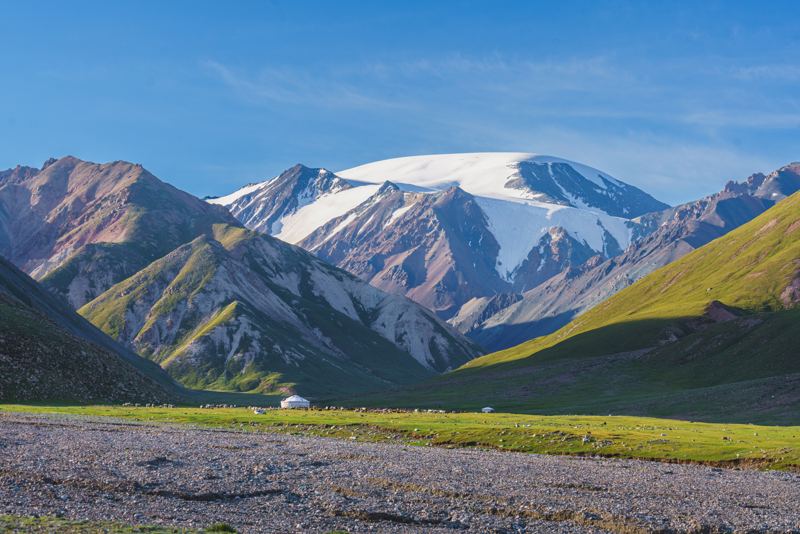 Snow-covered peaks above a green valley